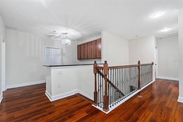 8625 Brixford St, Orlando, FL 32836 - corridor with dark wood-type flooring, an upstairs landing, baseboards, and an inviting chandelier