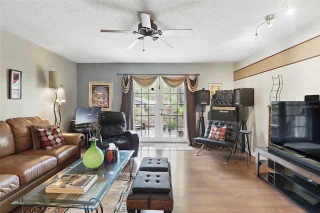 living room with ceiling fan, a textured ceiling, french doors, and wood finished floors