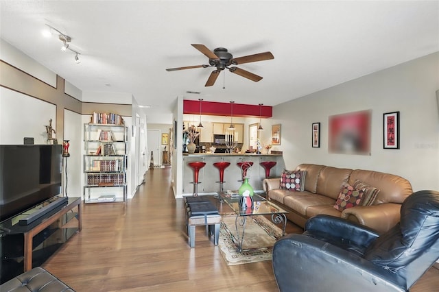 living room with wood finished floors and ceiling fan