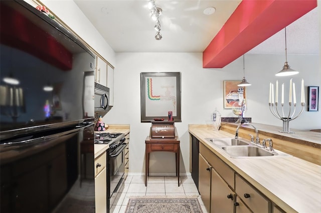 kitchen with light tile patterned floors, decorative light fixtures, a sink, light countertops, and black appliances