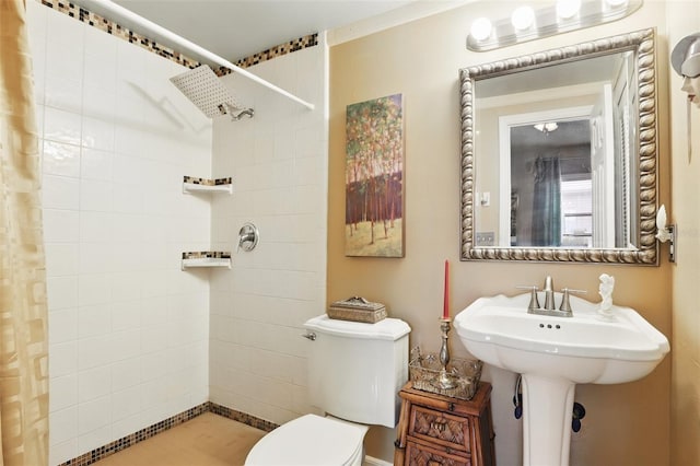 full bathroom with a tile shower and toilet