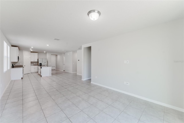 unfurnished living room featuring baseboards and recessed lighting