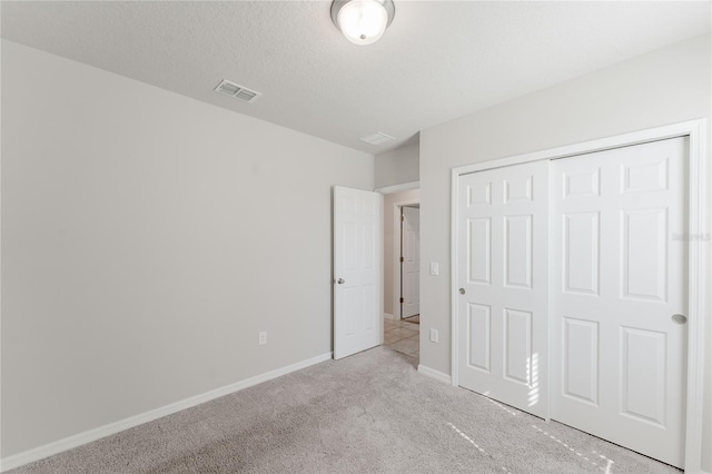 unfurnished bedroom with a closet, carpet flooring, baseboards, and visible vents