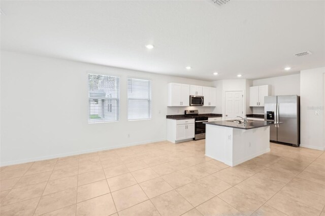 4717 Jasmine Cir, Leesburg, FL 34748 - kitchen featuring stainless steel appliances, dark countertops, recessed lighting, white cabinets, and a kitchen island with sink