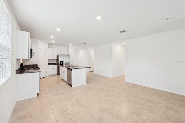 4717 Jasmine Cir, Leesburg, FL 34748 - kitchen featuring dark countertops, appliances with stainless steel finishes, recessed lighting, an island with sink, and white cabinets