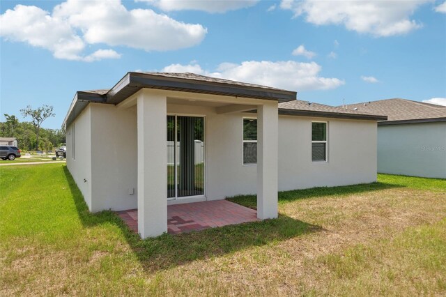 4717 Jasmine Cir, Leesburg, FL 34748 - rear view of house with stucco siding, a patio area, and a yard