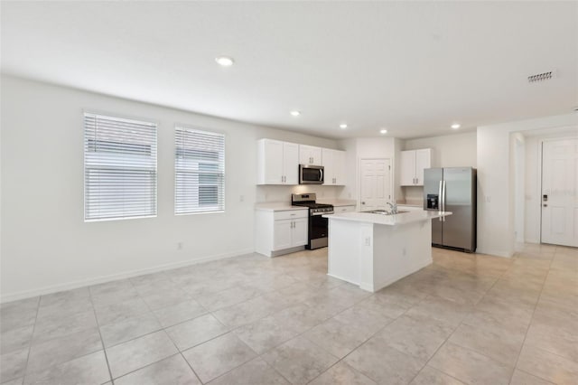 4732 Jasmine Cir, Leesburg, FL 34748 - kitchen featuring appliances with stainless steel finishes, a sink, light countertops, a kitchen island with sink, and white cabinetry