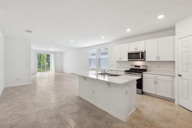4732 Jasmine Cir, Leesburg, FL 34748 - kitchen with appliances with stainless steel finishes, a sink, light countertops, white cabinetry, and a center island with sink