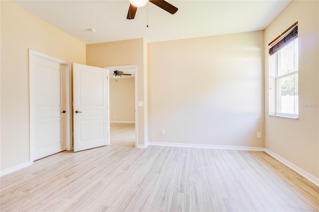 unfurnished room featuring light wood-style floors, a ceiling fan, and baseboards