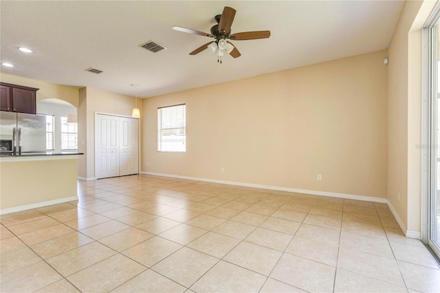 empty room with recessed lighting, visible vents, light tile patterned floors, arched walkways, and ceiling fan