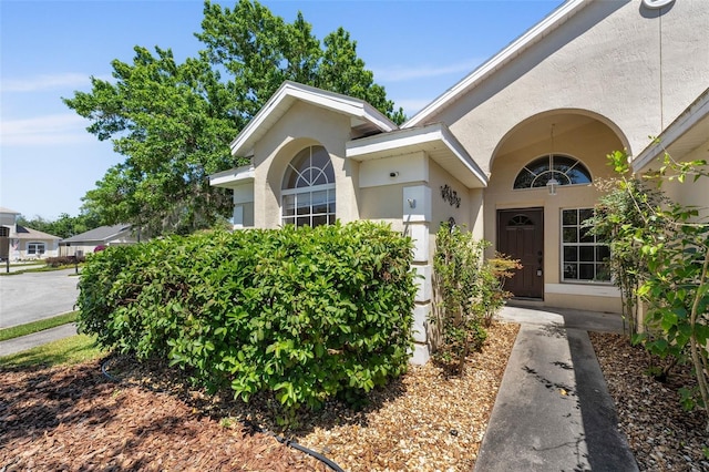 view of exterior entry featuring stucco siding