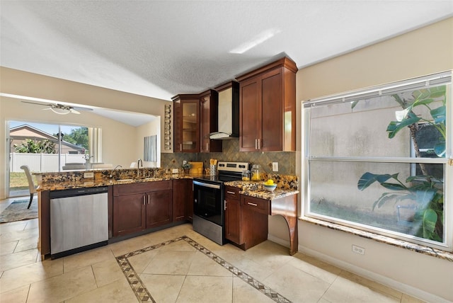 kitchen featuring wall chimney exhaust hood, stainless steel appliances, a sink, dark stone countertops, and backsplash