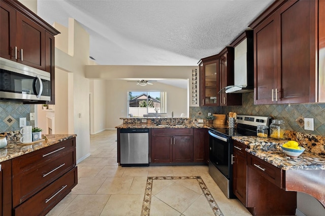 kitchen with a ceiling fan, tasteful backsplash, a sink, appliances with stainless steel finishes, and light stone countertops