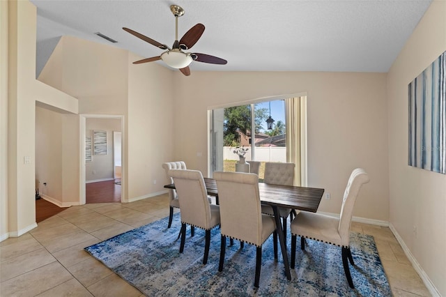 dining room featuring vaulted ceiling, visible vents, a ceiling fan, light tile patterned floors, and baseboards