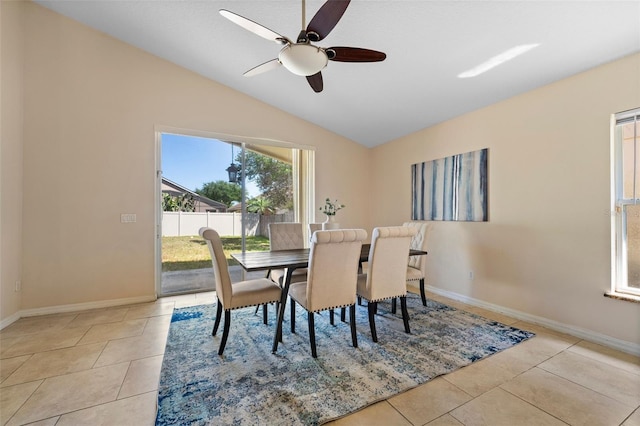 dining area with lofted ceiling, a ceiling fan, baseboards, and light tile patterned floors