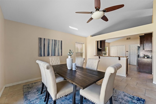 dining room featuring light tile patterned floors, lofted ceiling, baseboards, and ceiling fan