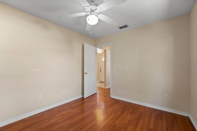 unfurnished room with wood finished floors, visible vents, baseboards, and ceiling fan