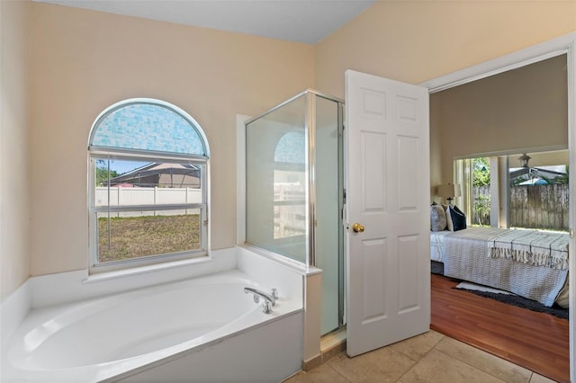 full bath featuring a garden tub, ensuite bathroom, tile patterned flooring, and a stall shower