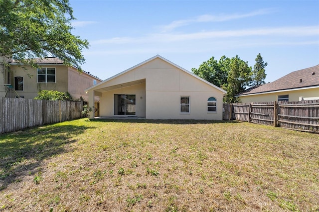 back of property featuring a fenced backyard and a yard