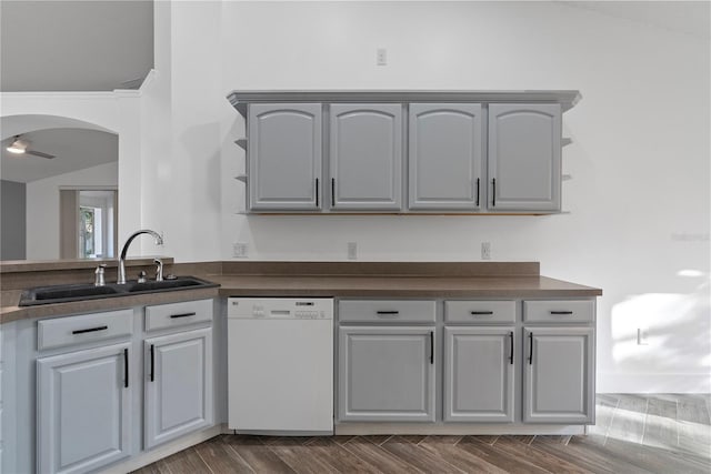 kitchen featuring dark countertops, open shelves, a sink, dishwasher, and gray cabinetry
