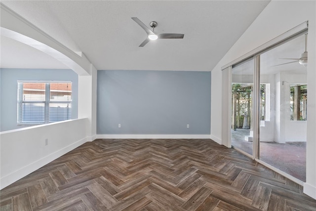 spare room featuring baseboards, a ceiling fan, and a wealth of natural light