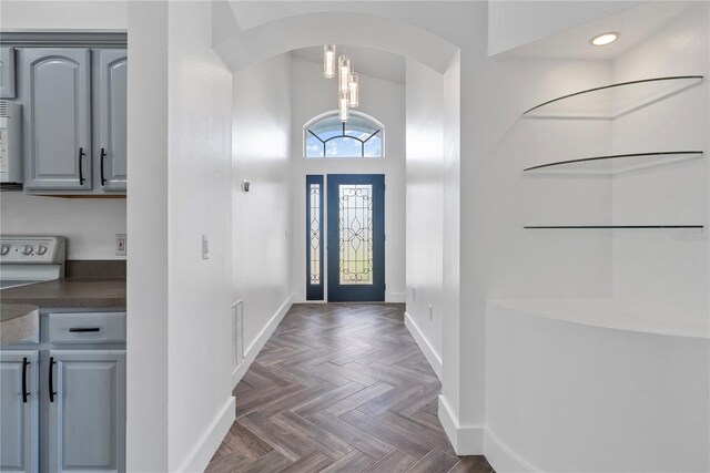 foyer with arched walkways, baseboards, a high ceiling, visible vents, and recessed lighting