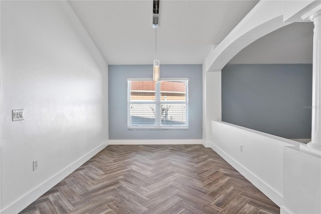 unfurnished dining area featuring arched walkways, baseboards, and decorative columns