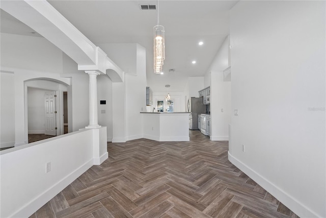 corridor featuring recessed lighting, ornate columns, visible vents, arched walkways, and baseboards