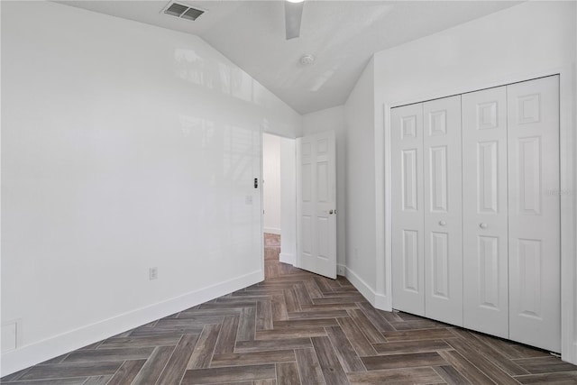 unfurnished bedroom featuring baseboards, visible vents, lofted ceiling, a closet, and ceiling fan