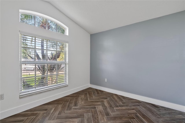 unfurnished room featuring vaulted ceiling and baseboards