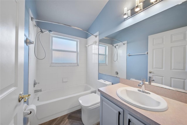 bathroom with vaulted ceiling, tub / shower combination, vanity, and toilet