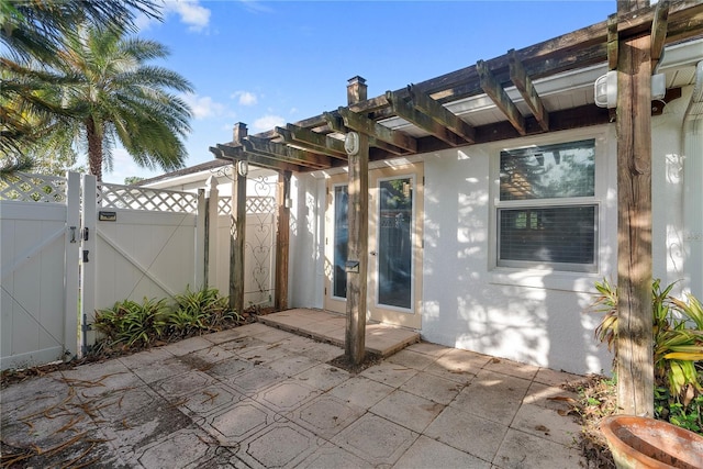 view of patio with fence, a pergola, and a gate