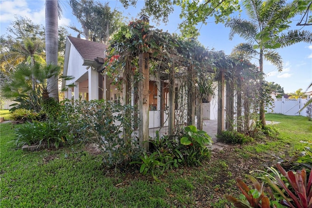 view of property exterior with fence, a yard, and stucco siding