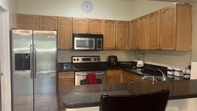 5125 Palm Springs Blvd Unit 13107, Tampa, FL 33647 - kitchen with brown cabinetry, a peninsula, dark countertops, and stainless steel appliances