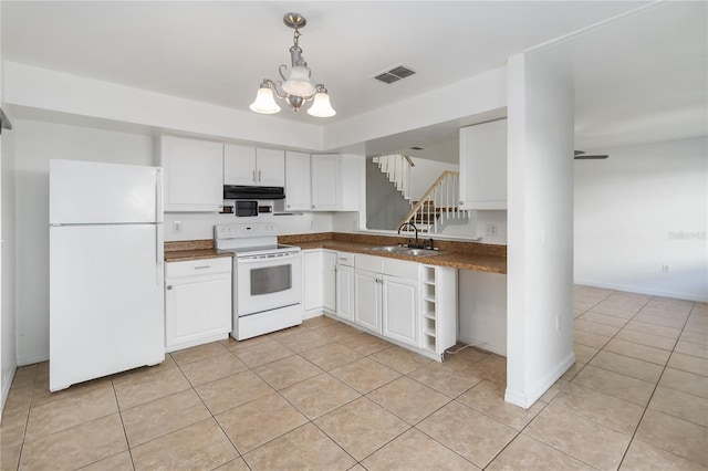kitchen with white appliances, light tile patterned floors, dark countertops, under cabinet range hood, and a sink