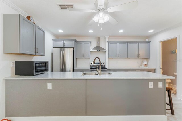 35 Misners Trl, Ormond Beach, FL 32174 - kitchen with stainless steel appliances, wall chimney exhaust hood, gray cabinetry, a sink, and crown molding