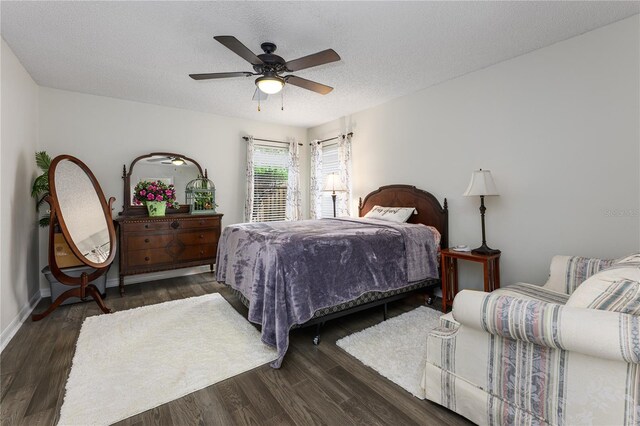 bedroom with ceiling fan, baseboards, wood finished floors, and a textured ceiling
