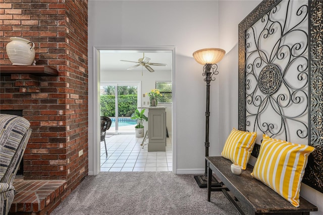 doorway to outside featuring tile patterned flooring, a ceiling fan, baseboards, and carpet