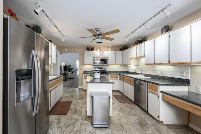 kitchen with rail lighting, appliances with stainless steel finishes, and a sink