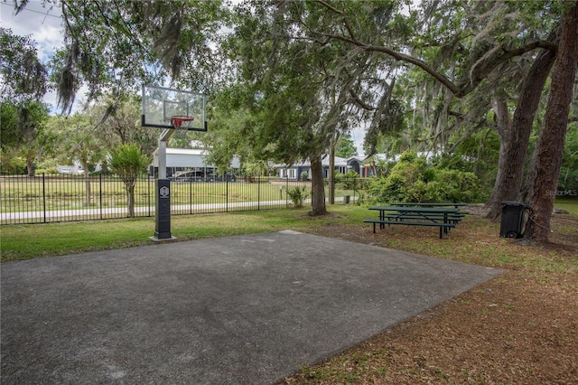 view of basketball court with fence, community basketball court, and a yard