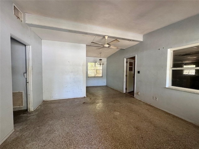unfurnished living room with a wealth of natural light, visible vents, and ceiling fan with notable chandelier