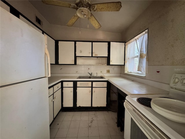 kitchen featuring light countertops, a sink, white cabinets, and white appliances