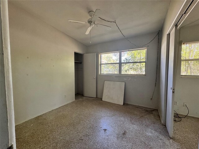 unfurnished bedroom with ceiling fan, multiple windows, and a closet