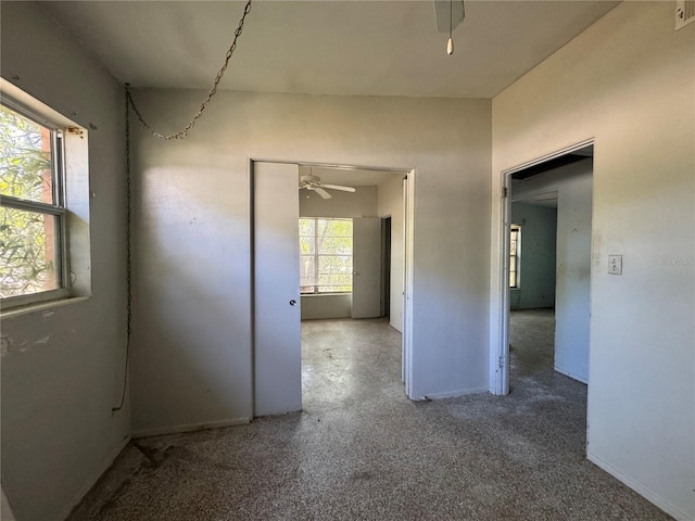 empty room featuring ceiling fan, visible vents, and baseboards