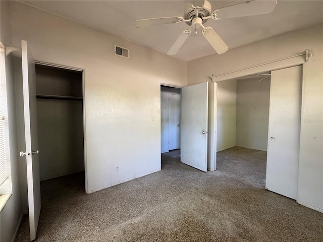 unfurnished bedroom with carpet flooring, visible vents, ceiling fan, and a closet