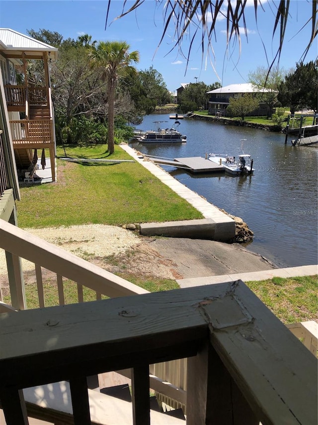 dock area featuring a water view and a lawn