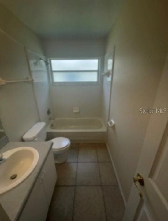 bathroom featuring vanity, toilet, tile patterned floors, baseboards, and tub / shower combination
