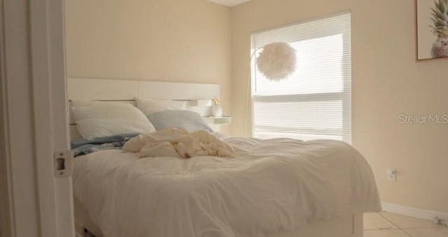 bedroom featuring tile patterned floors and baseboards