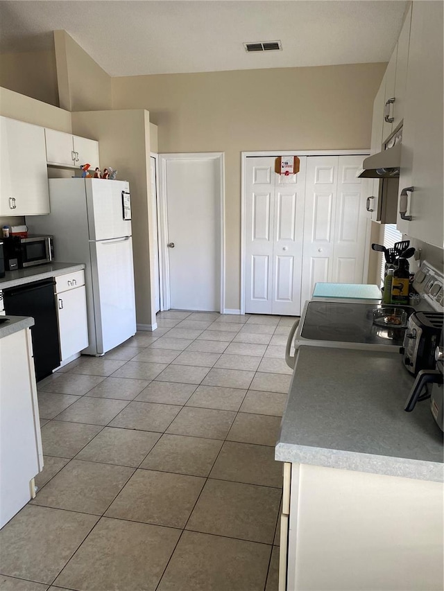 1567 Oak Hill Trl, Kissimmee, FL 34747 - kitchen featuring tile patterned floors, white cabinetry, dishwasher, freestanding refrigerator, and stainless steel microwave