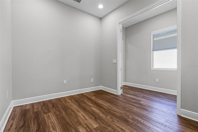 empty room with dark wood finished floors and baseboards